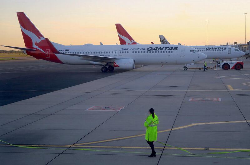 Workers can be seen near Qantas Airways, Australia's national carrier, Boeing 737-800 aircraft on the tarmac at Adelaide Airport, Australia, August 22, 2018. REUTERS/David Gray