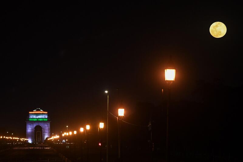 The pink supermoon shines above India Gate war memorial, in New Delhi, India.  AFP