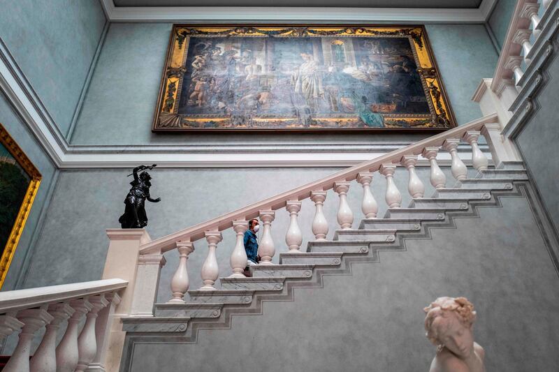 A visitor wearing a face mask climbs a flight of stairs at the Alte Nationalgalerie (Old National Gallery) museum in Berlin on May 12, 2020, after the museum reopened its doors to the public following a relaxation of lockdown restrictions.  AFP