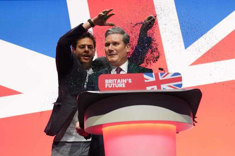 A protester throws glitter over Keir Starmer during his keynote speech at the Labour Party conference in Liverpool. PA