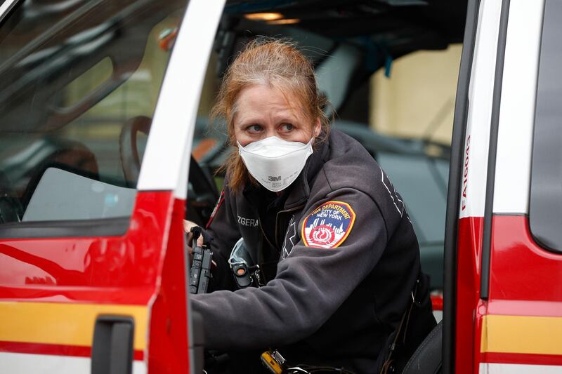 An FDNY medical worker wears personal protective equipment outside a COVID-19 testing site at Elmhurst Hospital Center, Wednesday, March 25, 2020, in New York. Gov. Andrew Cuomo sounded his most dire warning yet about the coronavirus pandemic Tuesday, saying the infection rate in New York is accelerating and the state could be as close as two weeks away from a crisis that sees 40,000 people in intensive care. Such a surge would overwhelm hospitals, which now have just 3,000 intensive care unit beds statewide. (AP Photo/John Minchillo)