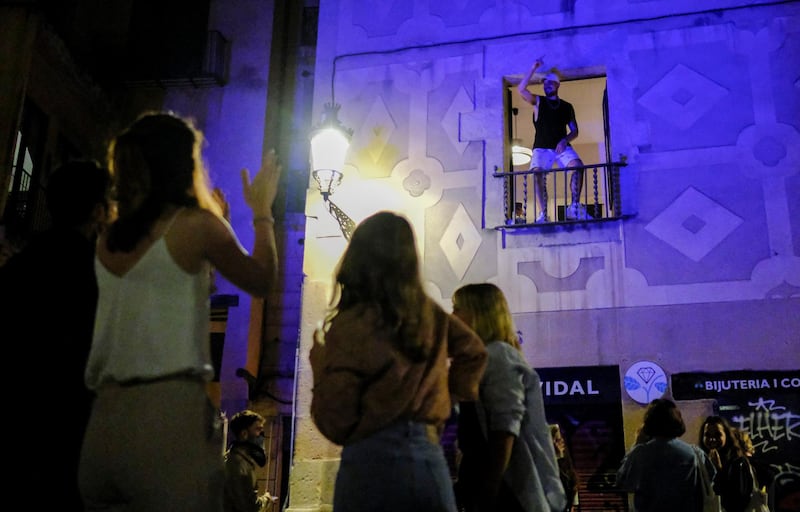 A resident of Barcelona dances on his balcony during street celebrations as Spain's coronavirus curfew ended on Saturday. Reuters