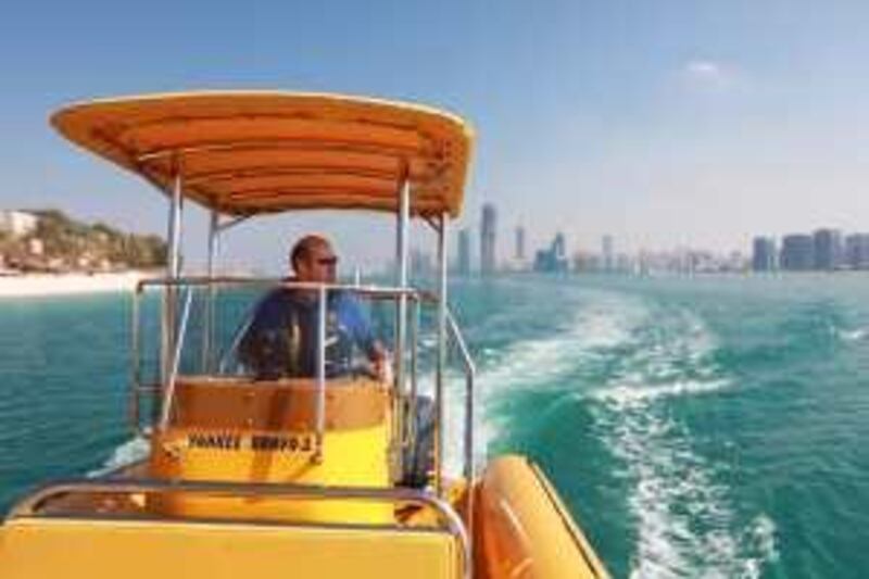 United Arab Emirates - Abu DHabi - January 13th, 2009:  Michael Phillips, Chief Executive of The Yellow Boats touring company, drives a speed boat equipped for groups of tourists along the corniche of Abu Dhabi.  (Galen Clarke/The National) *** Local Caption ***  GC01_01122010_TourBoat.jpg