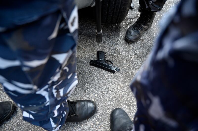 Members of the Lebanese security forces stand around a toy gun allegedly used by depositors in a hostage-taking situation, at a Blom Bank branch in Beirut. EPA