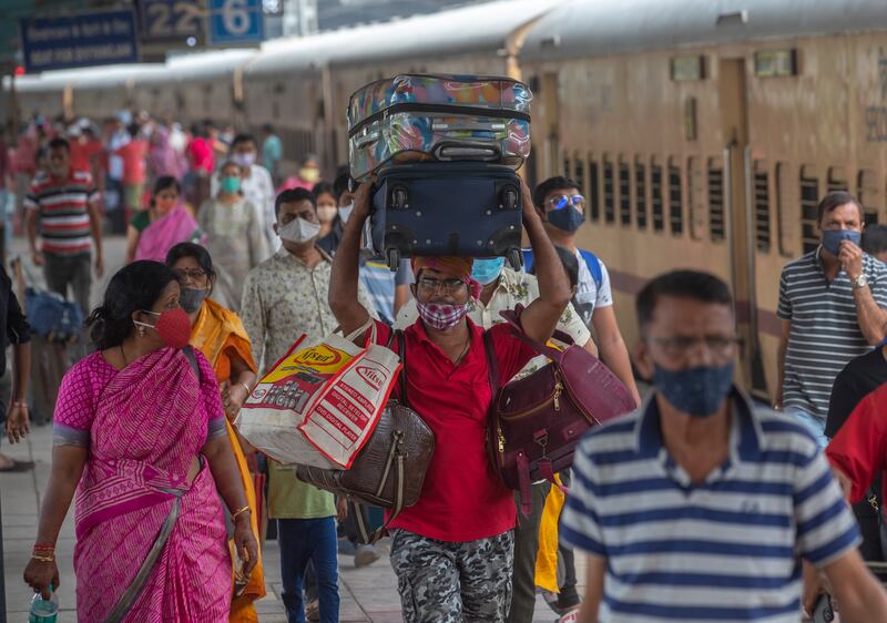 People wear masks as a precaution against the coronavirus at a station in Mumbai.  AP Photo