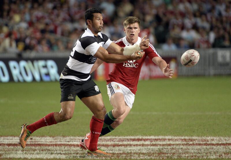 Casey Laulala of the Barbarians (L) passes the ball as Owen Farrell of the Lions (R) defends during the British and Irish Lions friendly rugby match against the Barbarians at Hong Kong Stadium on June 1, 2013.     AFP PHOTO / Philippe Lopez
 *** Local Caption ***  244061-01-08.jpg