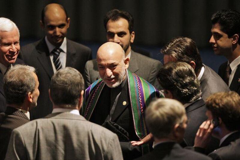 Afghanistan's president Hamid Karzai, centre, talks to Iran's delegation at the Afghanistan summit in The Hague yesterday.