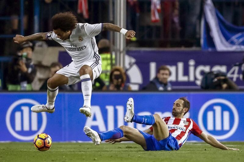 Real Madrid’s Brazilian defender Marcelo Vieira, left, fights for the ball with Atletico Madrid’s Juanfran. Emilio Naranjo / EPA