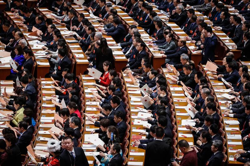 Delegates check their ballot tickets during the third plenary session of the 13th National People's Congress at the Great Hall of the People in Beijing, China. The NPC has over 3,000 delegates and is the world's largest parliament or legislative assembly. Roman Pilipey / EPA