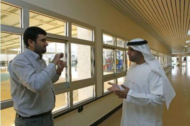 Hamad Al Darmaki, right, communicates with Abdullah Taljabini, his interpreter, through sign language at the National Association of the Deaf in Al Ain.