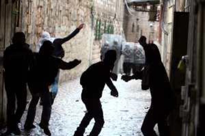 Palestinian youths throw stones at Israeli soldiers and policemen during clashes near the Al-Aqsa mosque compound in Jerusalem's old city on February 28, 2010. Clashes broke out at Jerusalem's flashpoint Al-Aqsa mosque compound on Sunday after police entered to arrest Palestinians who had hurled rocks at visitors they believed were Jewish extremists. AFP PHOTO/AHMAD GHARABLI *** Local Caption ***  977967-01-08.jpg