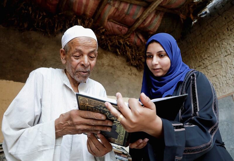 Abdallaa Abu Dawh, 82, a former teacher at Egypt's Al Azhar University who now works as an imam, reads with a woman in a library at his basement home which contains some 15,000 books he has collected. In his village in the Nile Delta, Dakahlia governorate, which is north of Cairo, he offers young men and women free books to read. 