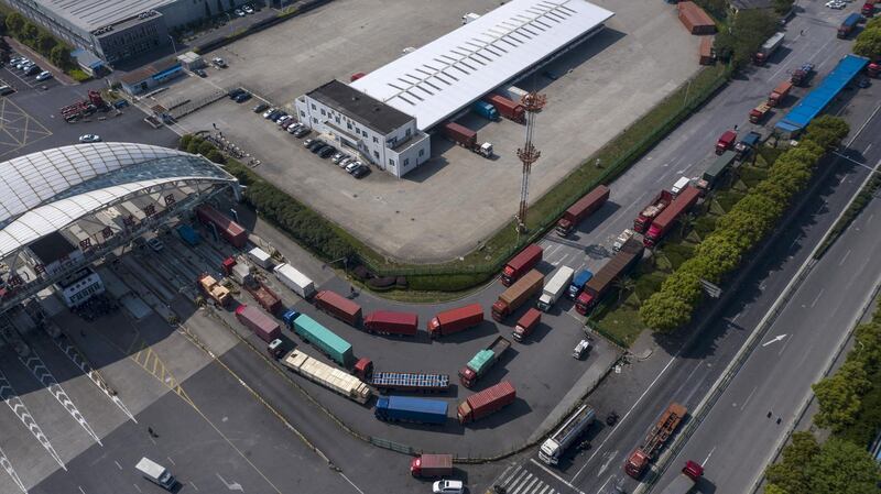 Trucks and semi-trailers wait in line to enter a logistics park in this aerial photograph taken on the outskirts of Shanghai, China, on Friday, 24, 2020. China is studying ways that it could accelerate purchases of U.S. farm goods to meet its phase-one trade deal commitments after the coronavirus delayed some imports, according to people familiar with the matter. Photographer: Qilai Shen/Bloomberg