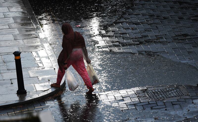 A woman walks in the rain in central London. EPA