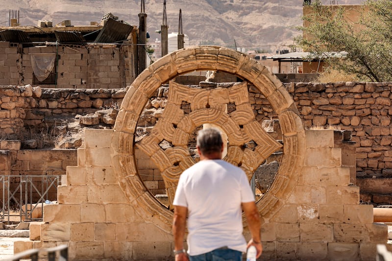 A tourist stands before a stone rosette at Hisham's Palace, an early Islamic site that Palestinian officials hope will be next to get a Unesco listing