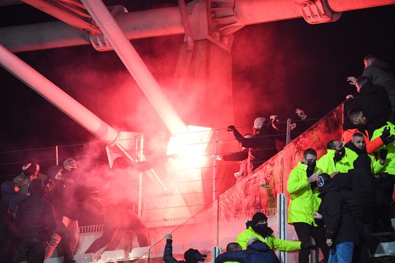Supporters hold a flare during the French Cup round of 64 football match between Paris FC and Olympique Lyonnais (OL) at the Charlety stadium in Paris, on December 17, 2021.  - The match was interrupted due to incidents in the stands.  At half-time, several flares were launched toward Lyon supporters, and two improvised explosive devices also exploded.  Spectators from this stand then descended on the lawn to move away from the scene of the incidents, preventing the resumption of the match.  (Photo by Bertrand GUAY  /  AFP)