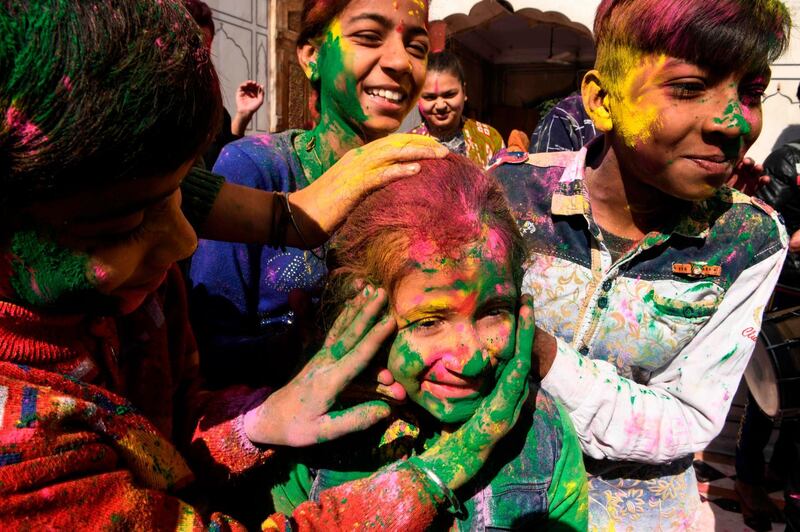 Children covered in colour powder celebrate Holi, the spring festival of colours, in Amritsar on March 9, 2020. AFP