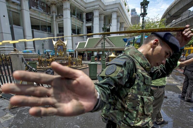 A member of military personnel stops the media from taking pictures at the Erawan shrine. Athit Perawongmetha / Reuters