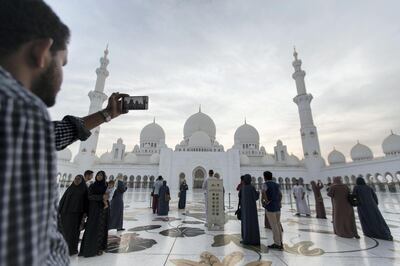 Abu Dhabi, United Arab Emirates, August 31, 2017:    A tourist takes a picture with a smartphone as the sun sets over Sheikh Zayed Grand Mosque ahead of Eid al-Adha in Abu Dhabi on August 31, 2017. Eid al-Adha, or the, Feast of the Sacrifice, honors the willingness of Ibrahim to sacrifice his son Ismaeel, as an act of obedience to God's command. Christopher Pike / The National

Reporter:  N/A
Section: News