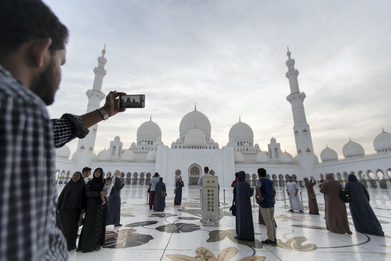 Abu Dhabi, United Arab Emirates, August 31, 2017:    A tourist takes a picture with a smartphone as the sun sets over Sheikh Zayed Grand Mosque ahead of Eid al-Adha in Abu Dhabi on August 31, 2017. Eid al-Adha, or the, Feast of the Sacrifice, honors the willingness of Ibrahim to sacrifice his son Ismaeel, as an act of obedience to God's command. Christopher Pike / The National

Reporter:  N/A
Section: News