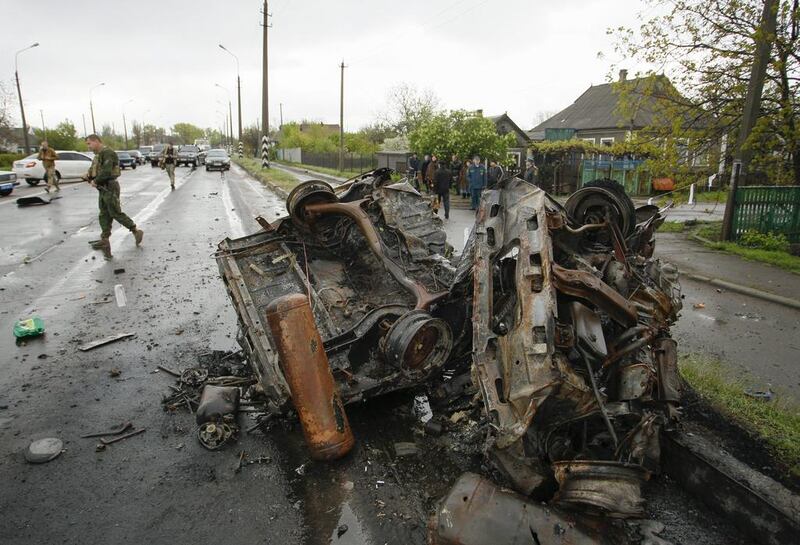 Local citizens look at a damaged car after shelling near a pro-Russian rebel’s checkpoint, close to the border with Ukraine-controlled territory in Elenovka village in Donetsk area, Ukraine. At least four civilians were killed and eight injured as a result of morning shelling there. Alexander Ermochenko / EPA