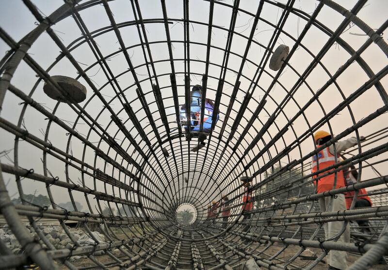 Labourers work at the construction site of a bridge being built for metro rail in New Delhi, India, November 30, 2015. REUTERS/Anindito Mukherjee - GF20000079682
