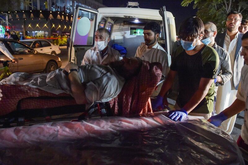 Volunteers and medical staff bring an injured man for treatment. AFP