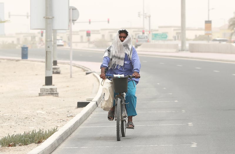 DUBAI , UNITED ARAB EMIRATES , JULY 30 – 2018 :- One of the worker covering his face during the dusty and hot weather in Jumeirah Park area in Dubai. ( Pawan Singh / The National )  For News.