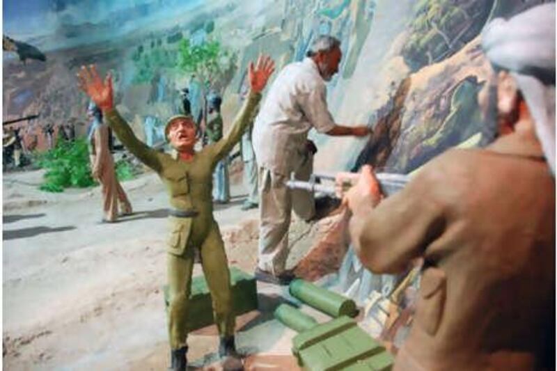 Nasrallah Sarway, the head artist at the Manzar-e-Jahad Museum does touch up work on the diorama he helped create.