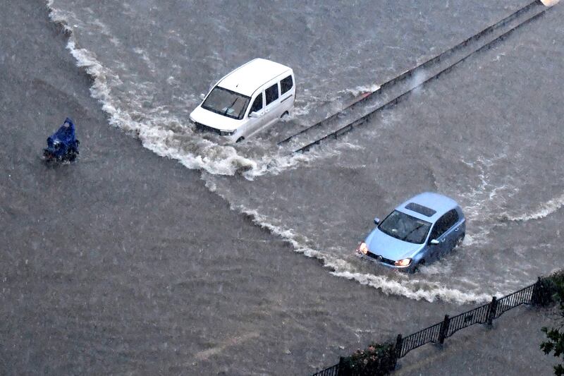 Vehicles pass through floodwater in Zhengzhou.