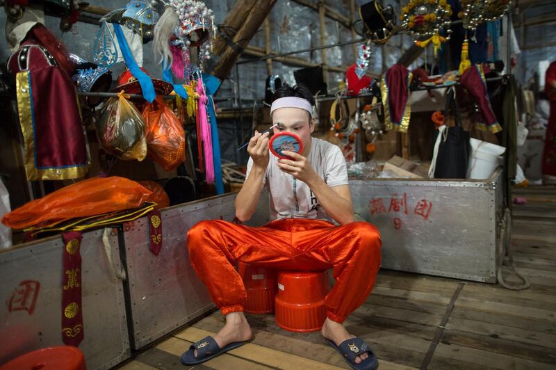 A Chinese opera actor makes up in the backstage of a temporary bamboo theater in celebrations of the Hungry Ghost Festival in Hong Kong. EPA