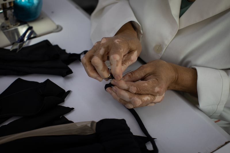 Laure Bassil manually sews a piece of fabric. Diamony Group produces up to 3,000 garments a month.