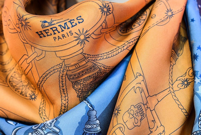 A model wears a Hermes double-sided scarf in Paris on December 4, 2019. - Hermes will unveil next week a "double-sided" silk scarf, which is different on the front from the back. It is a small revolution for the luxury manufacturer and a technical innovation, which is still little mastered in the world of silk printing. (Photo by ALAIN JOCARD / AFP) / RESTRICTED TO EDITORIAL USE - MANDATORY MENTION OF THE ARTIST UPON PUBLICATION - TO ILLUSTRATE THE EVENT AS SPECIFIED IN THE CAPTION
