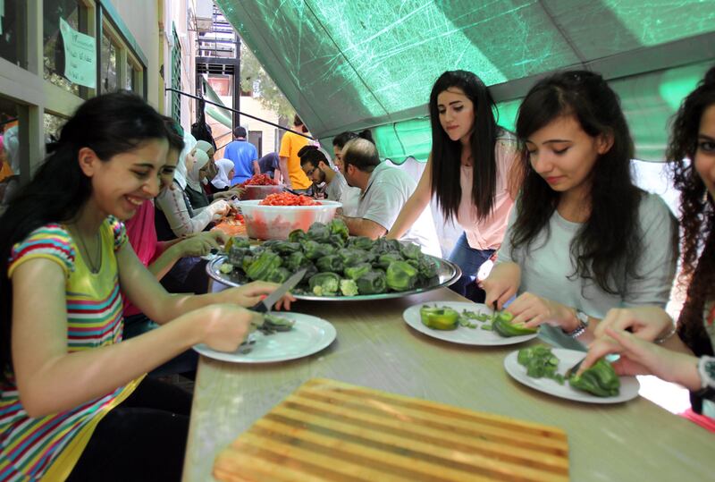 Volunteers prepare Ramadan meals for people in need in Damascus’s Al Mazzeh neighbourhood yesterday. Youssef Badawi / EPA