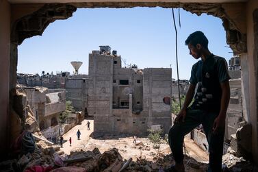 Mahmoud Al-Masri, 14, stands for a portrait in his bedroom that was damaged when an airstrike destroyed the neighboring building prior to a cease-fire that halted an 11-day war between Gaza's Hamas rulers and Israel, Wednesday, May 26, 2021, in Beit Hanoun, Gaza Strip. AP