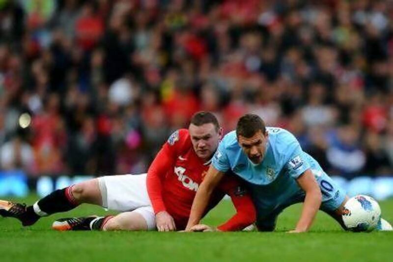Wayne Roney, left, the Manchester United striker, and Edin Dzeko, right, of Manchester City, may well lock horns again in tonight's match at Etihad Stadium. Laurence Griffiths / Getty Images