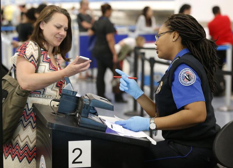 A TSA officer with a traveller at Miami airport. Border guards are increasingly pressing travellers to open up devices. Wilfredo Lee / AP Photo