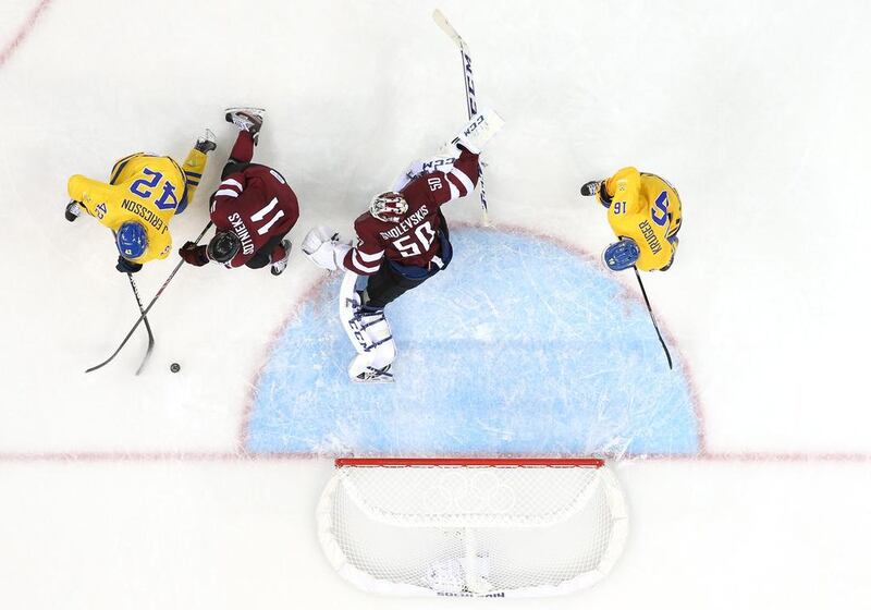 Jimmie Ericsson, No 42 of Sweden, scores against Kristers Gudlevskis, No 50 of Latvia, in the second period during the men's ice hockey group game on at Shayba Arena on Saturday. Martin Rose / Getty Images
