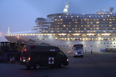 A coach and an ambulance travel towards the Diamond Princess cruise ship, operated by Carnival Corp., docked at dusk in Yokohama, Japan. Bloomberg
