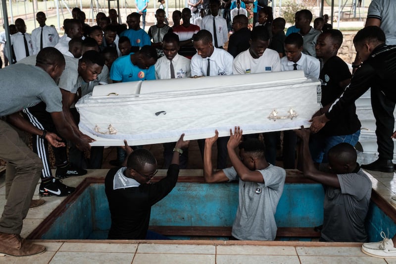 Men bury a coffin containing the newly discovered remains of a victim of the 1994 Rwanda genocide at a memorial in the capital, Kigali. The country is still coming to terms with the brutal violence 30 years ago that the UN estimates claimed more than a million lives. AFP