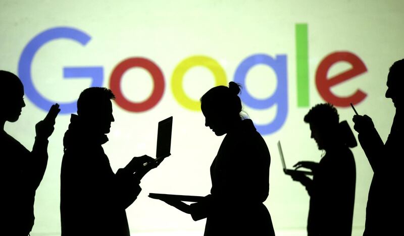 FILE PHOTO: Silhouettes of laptop and mobile device users are seen next to a screen projection of Google logo in this picture illustration taken March 28, 2018.  REUTERS/Dado Ruvic/Illustration/File Photo
