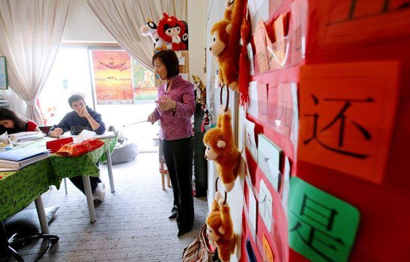 Jenny Tang teaches Mandarin to Zainab Majid, 13, and Ramzi Sharif, 17, at her flat in Abu Dhabi. Mrs Tang also teaches Mandarin at Zayed University, which will be home to the Confucius Institute.