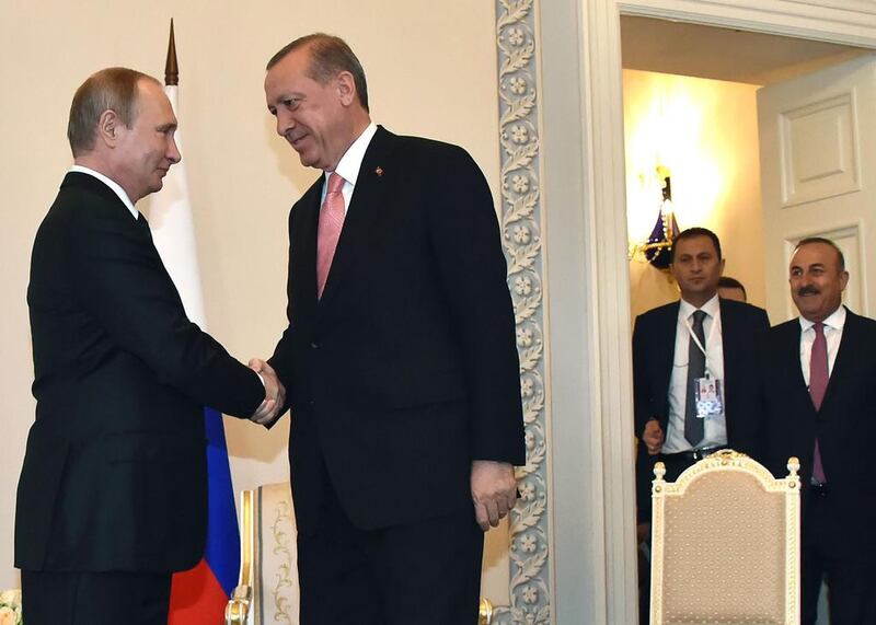 Russian president Vladimir Putin (L) shakes hands with Turkish president Recep Tayyip Erdogan (C) as Turkish foreign minister Mevlut Cavusoglu (R) looks on, before their meeting on August 9, 2016. Alexander Nemenov/AFP

