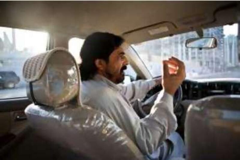 Abu Dhabi - October 6, 2008:  Taxi driver Rab Nawaz Nawaz Mir, from Pakistan speaks arabic, urdu, farsi, dari, and pashtu, drives his cab in Abu Dhabi. ( Philip Cheung / The National ) *** Local Caption ***  PC0048-language2.jpg