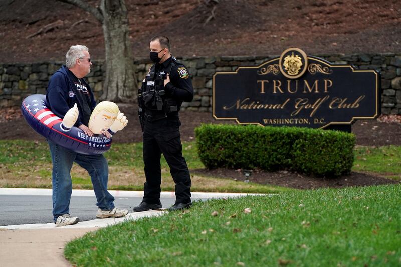 A supporter of U.S. President Donald Trump speaks to a police officer as he waits for Trump to depart the Trump National Golf Club in Sterling, Virginia. Reuters