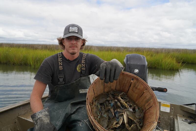 Mr Evans poses with a bushel of crabs he caught. 