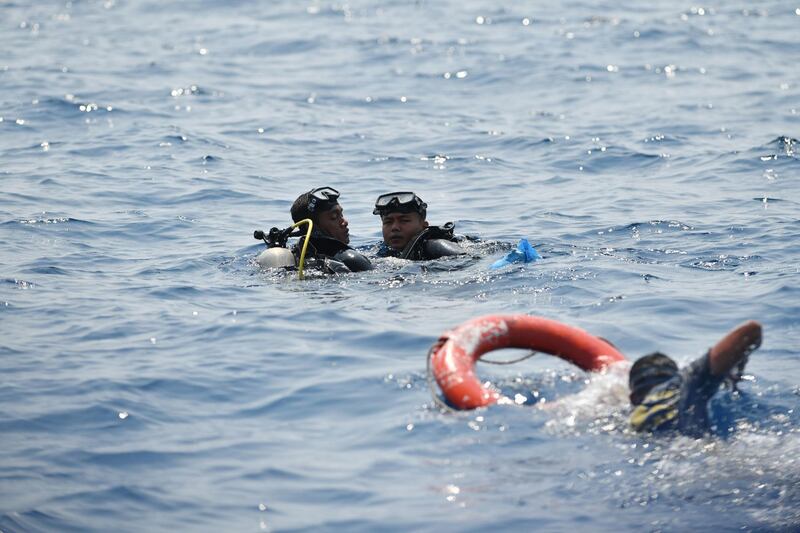 Indonesian Navy divers carry debris and remains during search operations. AFP