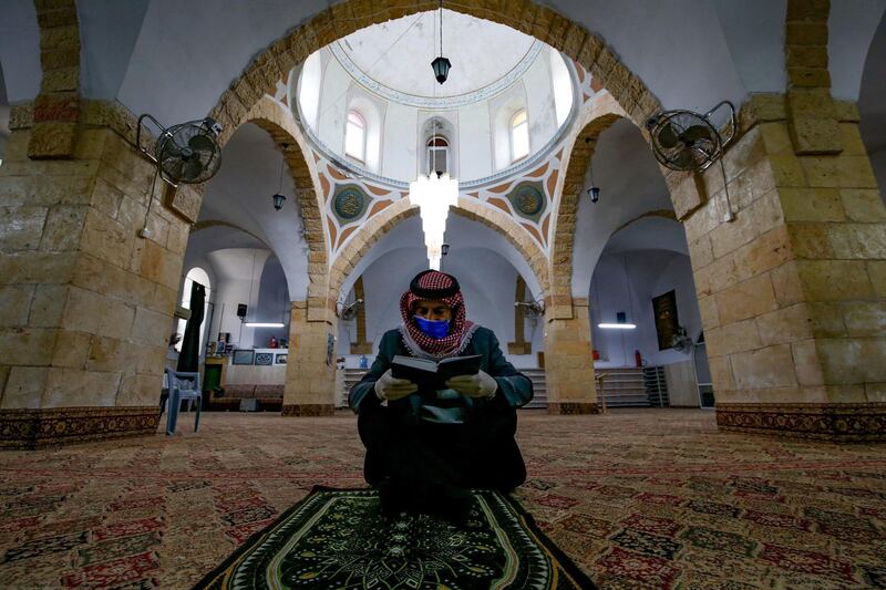 A Palestinian man reads the Koran alone at the al-Qazazin mosque in the occupied West Bank town of Hebron. AFP