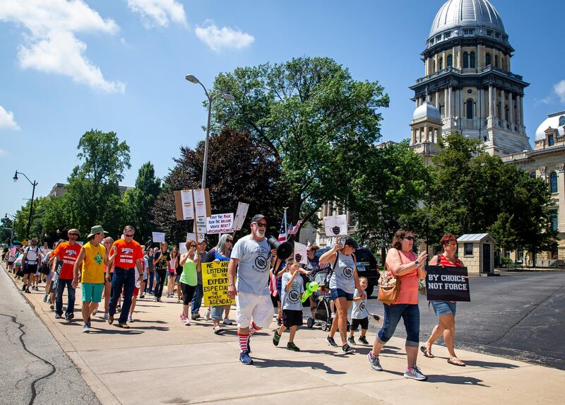 Michael Rebresh, one of the organisers of the "Million Unmasked March," leads the group of protesters as they march towards the Illinois State Board of Education at the Illinois State Capitol.  AP