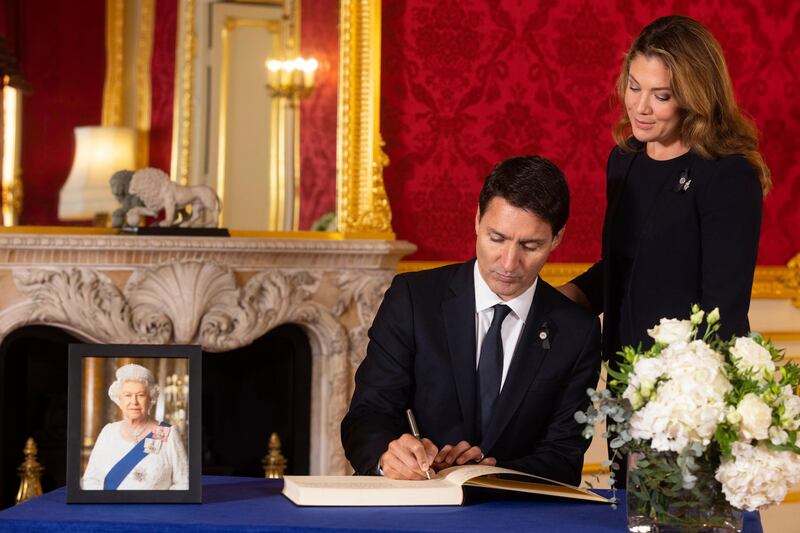 Prime Minister of Canada Justin Trudeau signs a book of condolence for Queen Elizabeth as his wife Sophie looks on. AP